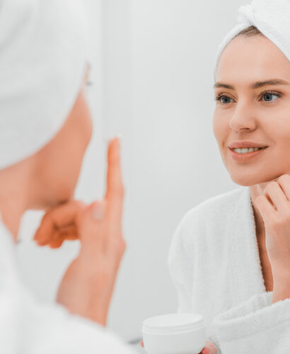 woman applying face cream to treat melasma