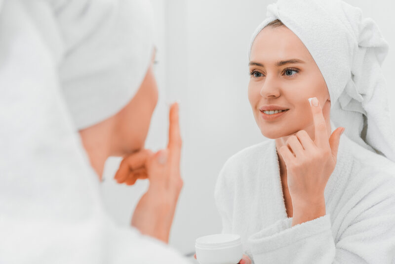 woman applying face cream to treat melasma